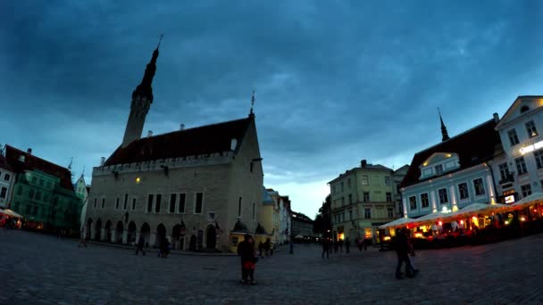 Туристы посещают вечернюю Ратушную площадь в Старом городе Таллинна, Эстония — стоковое видео