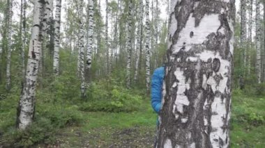 Güzel kadın bir gülümseme ile huş bakıyor ve saç dalgalar. Ağır çekim