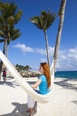 arka plan gökyüzü ve okyanus üzerinde hamakta kadın