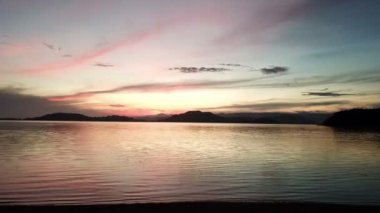 Deniz ve dağlık adalar üzerinde dramatik günbatımı, gökyüzünde bulutlar. Lombok, Endonezya yakınlarındaki küçük Gili Asahan adasından görüntü