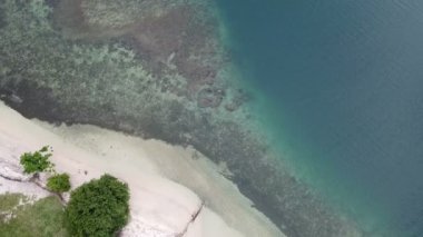 Lombok, Endonezya, Güney Gili adaları. Gili Asahan adasından insansız hava aracı görüntüsü. Kumsalda bir kum şeridi ve mercanlı mavi deniz.
