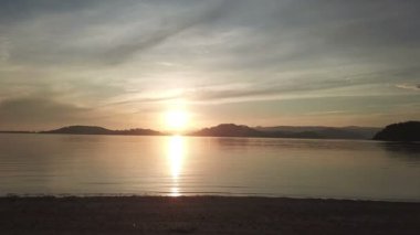 Deniz ve dağlık adalar üzerinde dramatik günbatımı, gökyüzünde bulutlar. Lombok, Endonezya yakınlarındaki küçük Gili Asahan adasından görüntü