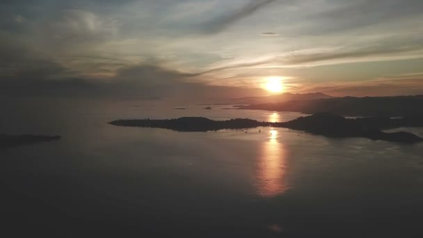 Drohnenblick aus der Luft, dramatischer Sonnenuntergang über dem Meer und den bergigen Inseln, Wolken am Himmel. Blick von der kleinen Insel Gili Asahan in der Nähe von Lombok, Indonesien — Stockvideo