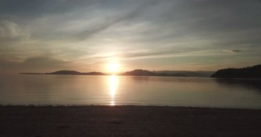 Deniz ve dağlık adalar üzerinde dramatik günbatımı, gökyüzünde bulutlar. Lombok, Endonezya yakınlarındaki küçük Gili Asahan adasından görüntü