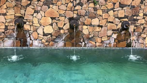 Wall Fountain Waterspout in een zwembad in een tropisch resort, slow motion — Stockvideo