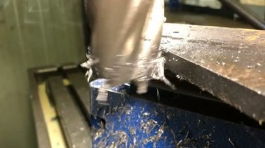 Metal işçiliği. Uç değirmen kesicisi evrensel bir dikey değirmen makinesinin makine kaldırma parçalarını işliyor. yavaş çekim
