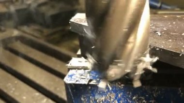Metal işçiliği. Uç değirmen kesicisi evrensel bir dikey değirmen makinesinin makine kaldırma parçalarını işliyor. yavaş çekim