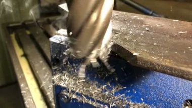 Metal işçiliği. Uç değirmen kesicisi evrensel bir dikey değirmen makinesinin makine kaldırma parçalarını işliyor. yavaş çekim