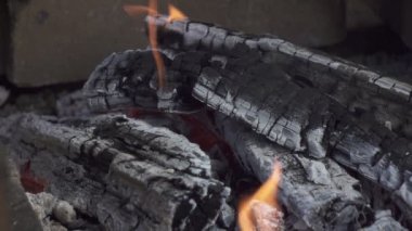 Caddedeki bir brazier 'da yanan ahşap kütükler, kır evindeki sokak mangasında yanan ahşap raflar, açık ateşte barbekü hazırlığı için kömür hazırlığı, barbekü.,
