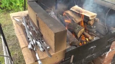Köy evinin yakınındaki bir mangalda odun yanığı, ateşte pişirme hazırlığı, Shashlyk, sosis, barbekü...