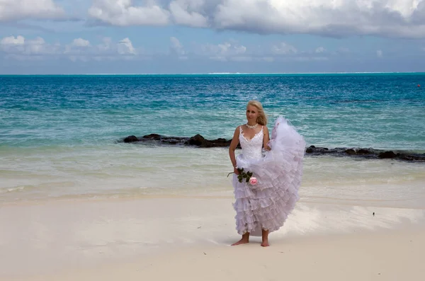美丽的女人穿着新娘的衣服站在海边 — 图库照片