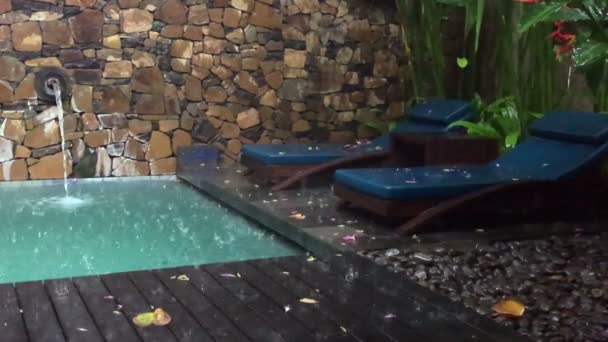 Pioggia tropicale al resort, gocce di pioggia gocciolano in piscina e lettini, rallentatore — Video Stock