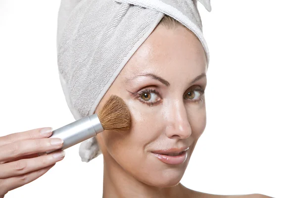 Mooie jonge vrouw in handdoek met een borstel voor een make-up — Stockfoto