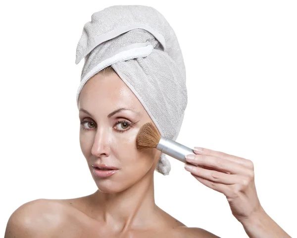 Mooie jonge vrouw in handdoek met een borstel voor een make-up — Stockfoto