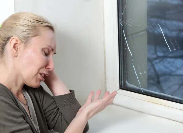 El ama de casa molesta y cuenta dinero para la reparación de la ventana, que ha estallado en la helada — Foto de Stock