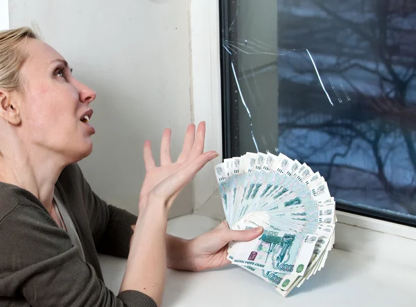 La femme au foyer bouleversé et compte l'argent pour la réparation d'une fenêtre qui a éclaté dans un gel — Photo