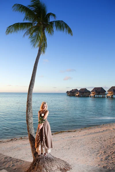 The young woman in a long sundress on a tropical beach. Polynesia. — Stock Photo, Image