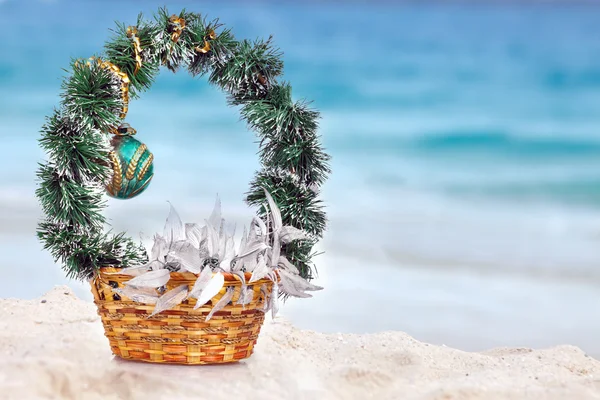 Cesta con decoraciones navideñas en una playa en la región del mar —  Fotos de Stock