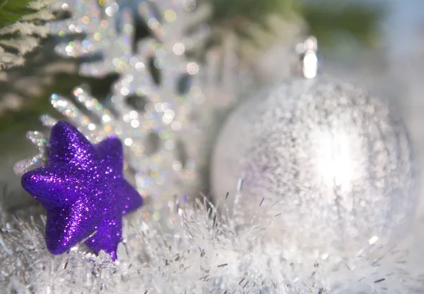 Dekoratives violettes Spielzeug, eine Schneeflocke und ein silberfarbener Neujahrsball aus dem Fokus — Stockfoto