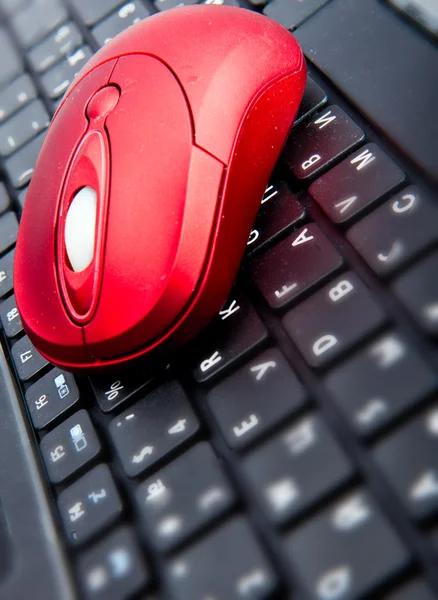 El ratón rojo de la computadora en el teclado negro —  Fotos de Stock