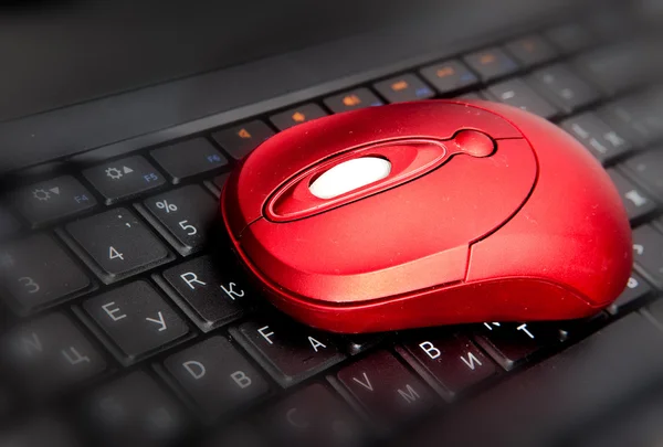 The red computer mouse on the black keyboard — Stock Photo, Image