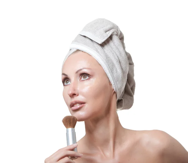 Piękna młoda kobieta w ręczniku z pędzlem do makijażu — Zdjęcie stockowe