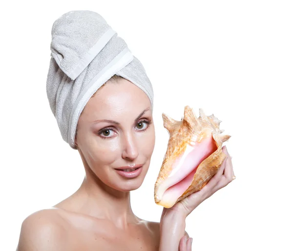 A menina bonita jovem em uma toalha na cabeça com uma concha do mar grande — Fotografia de Stock