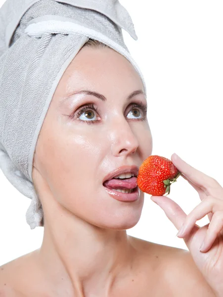Schöne junge Frau im Handtuch mit einer Erdbeere — Stockfoto