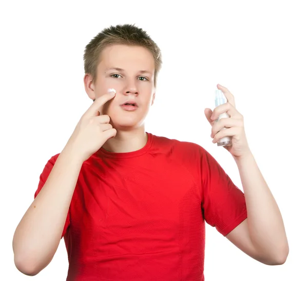 Der Junge, der Teenager mit einer Creme für eine jugendliche Problemhaut, gegen Flecken — Stockfoto