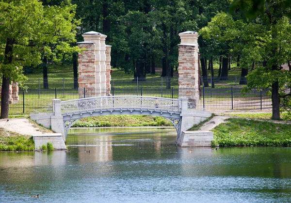 Mały most wytarty w parku nad stawem. Gatchina. Petersburg. Rosja — Zdjęcie stockowe