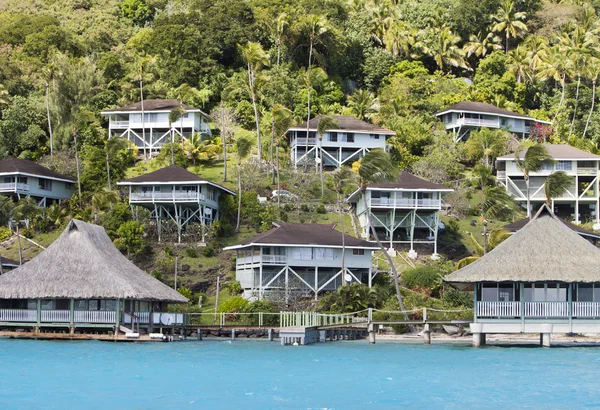 Hügel am Meer und Hütten am Hang. Polynesien. — Stockfoto