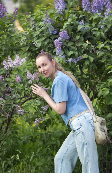 Giovane donna vicino alla fioritura lila — Foto Stock