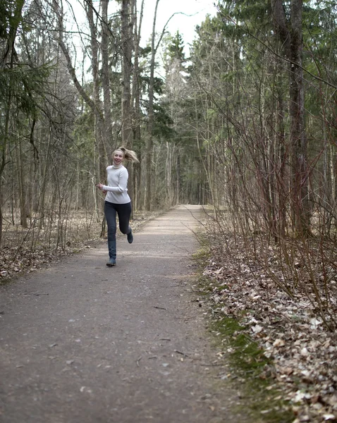 The woman runs on the track in the spring wood — Stock Photo, Image