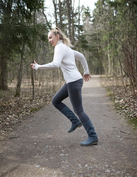 The woman runs on the track in the spring wood — Stock Photo, Image