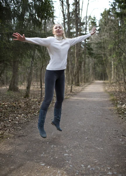 La mujer corre en la pista en el bosque de primavera —  Fotos de Stock