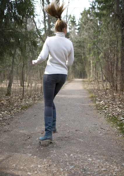 The woman runs on the track in the spring wood — Stock Photo, Image