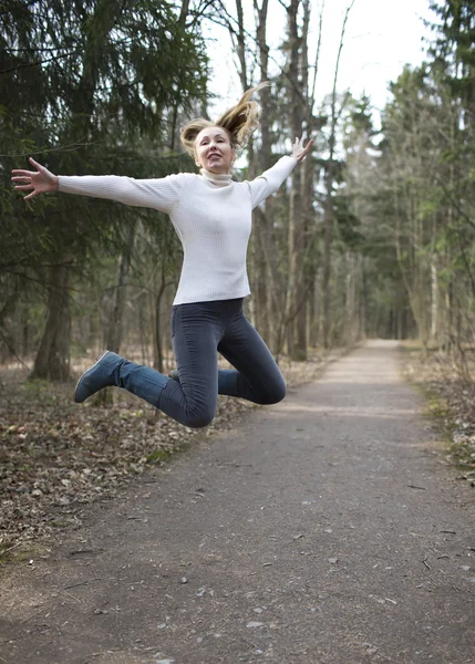La mujer corre en la pista en el bosque de primavera —  Fotos de Stock