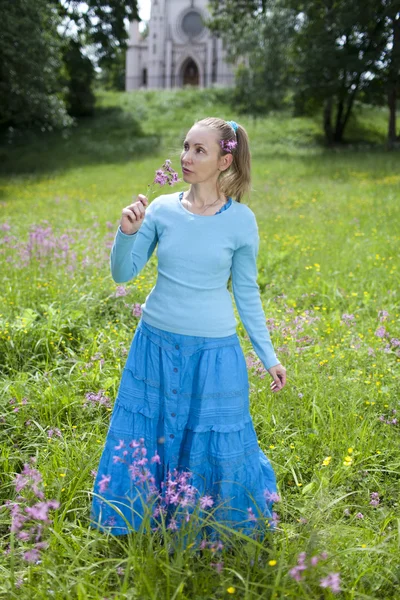 La jeune femme heureuse dans le domaine des fleurs sauvages — Photo