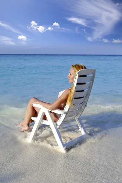 Deniz bir plaj sandalyesi genç güzel kadın — Stok fotoğraf