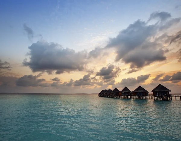 Häuser über dem Meer bei Sonnenaufgang. Malediven — Stockfoto