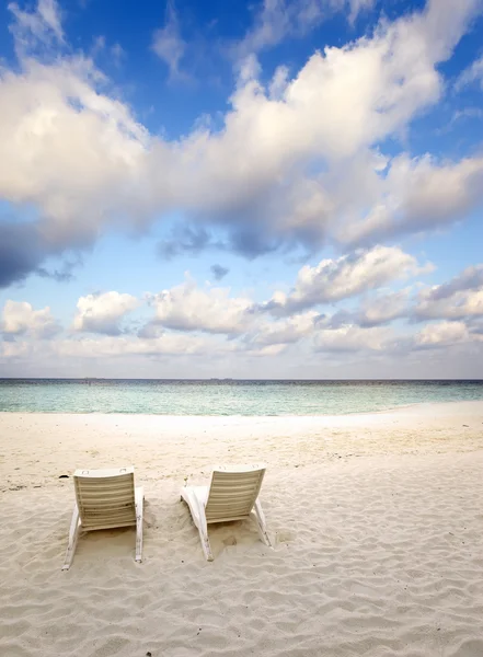 Sedie da spiaggia vuote sulla sabbia vicino al mare all'alba — Foto Stock
