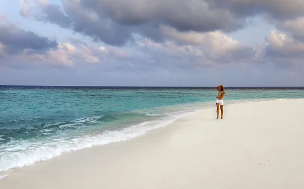 Žena vede na pobřeží moře, Maledivy — Stock fotografie