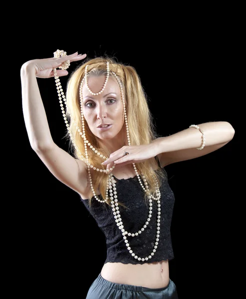 Beautiful young blonde woman with long hair and a pearl beads on dark background — Stock Photo, Image