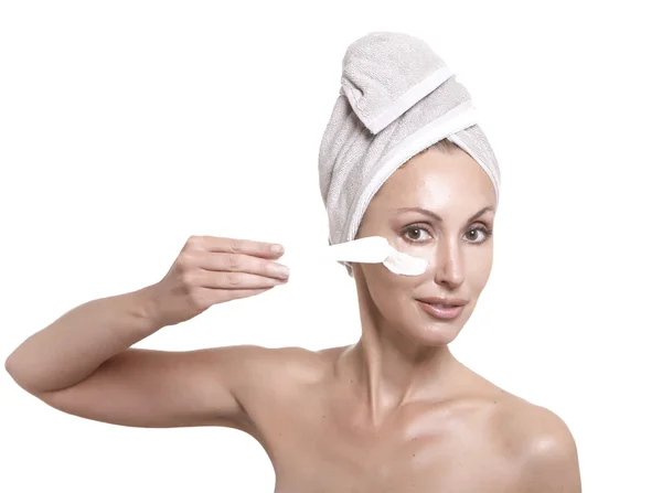 Krásná mladá žena v ručníku s kosmetickým krémem — Stock fotografie