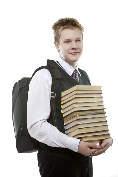 O estudante em um uniforme escolar com um enorme pacote de livro — Fotografia de Stock