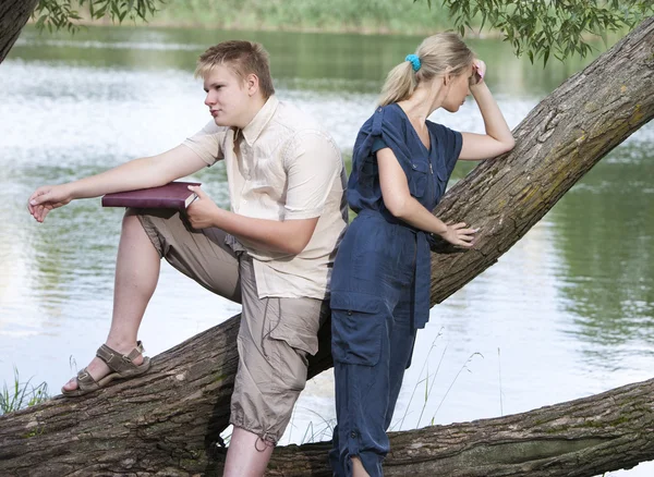 El tipo y la chica en disputa en la orilla del lago — Foto de Stock