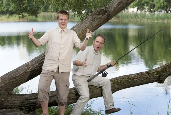 The father with the son on fishing, shows the size of fish — Stock Photo, Image