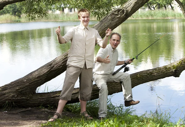 The father with the son on fishing, shows the size of fish — Stock Photo, Image