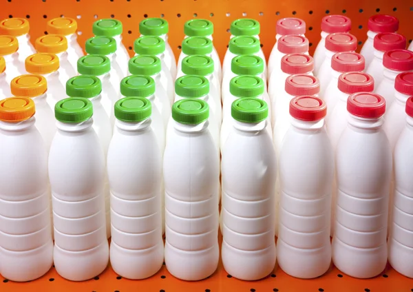 Dairy products bottles with bright covers on a shelf in the shop — Stock Photo, Image