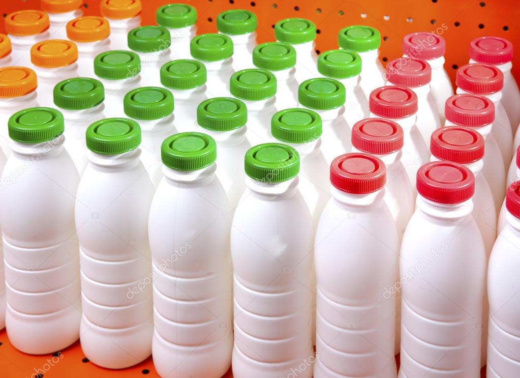 Dairy products bottles with bright covers on a shelf in the shop